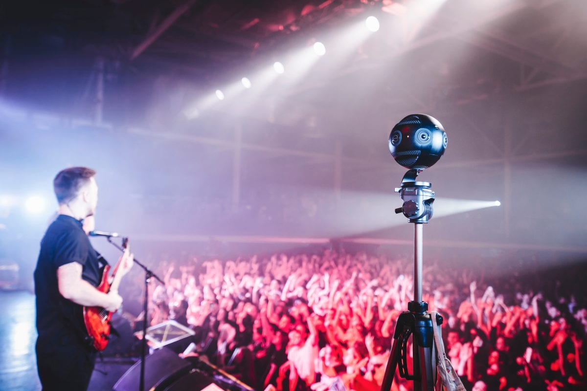 A 360 camera recording the concert performance on a tripod.