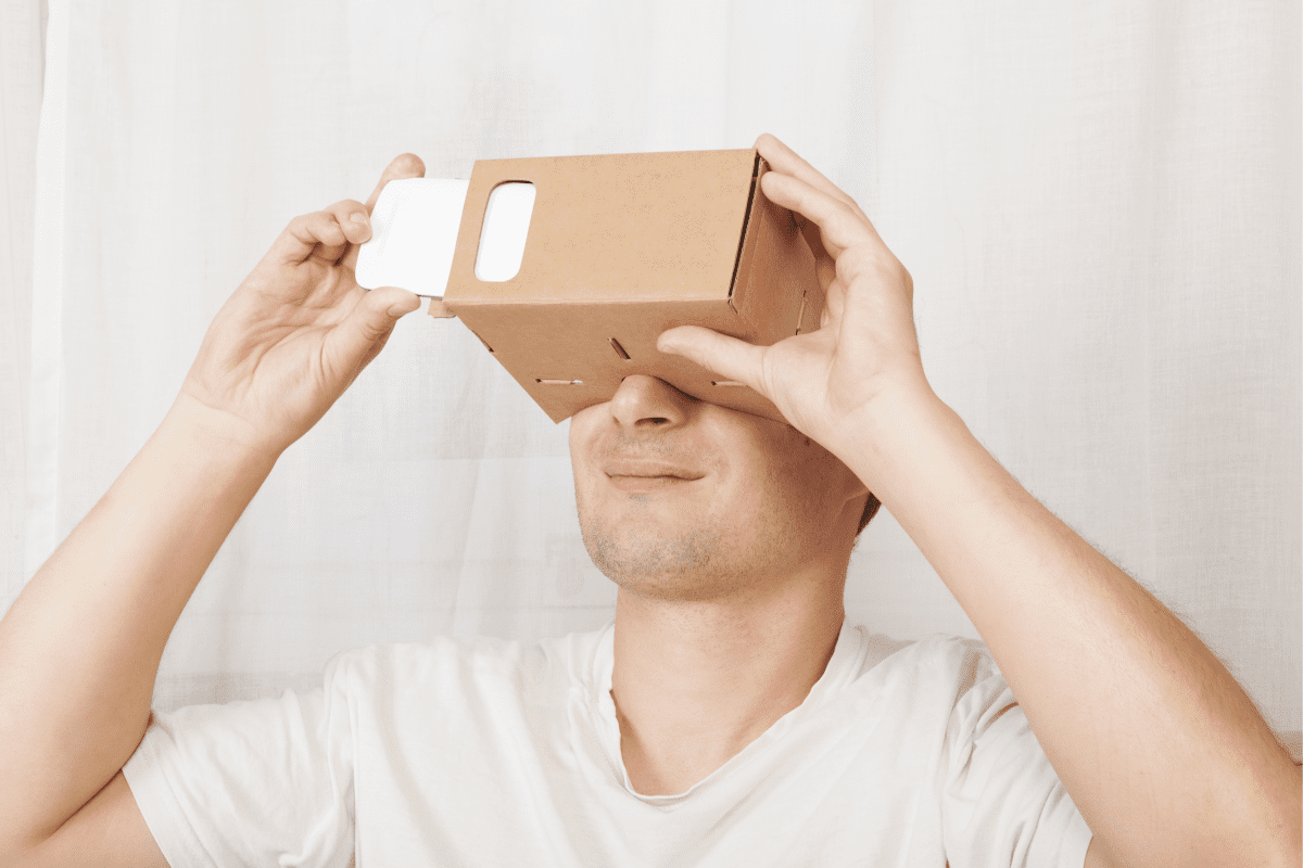 Adult man using cardboard virtual reality gloves cardboard